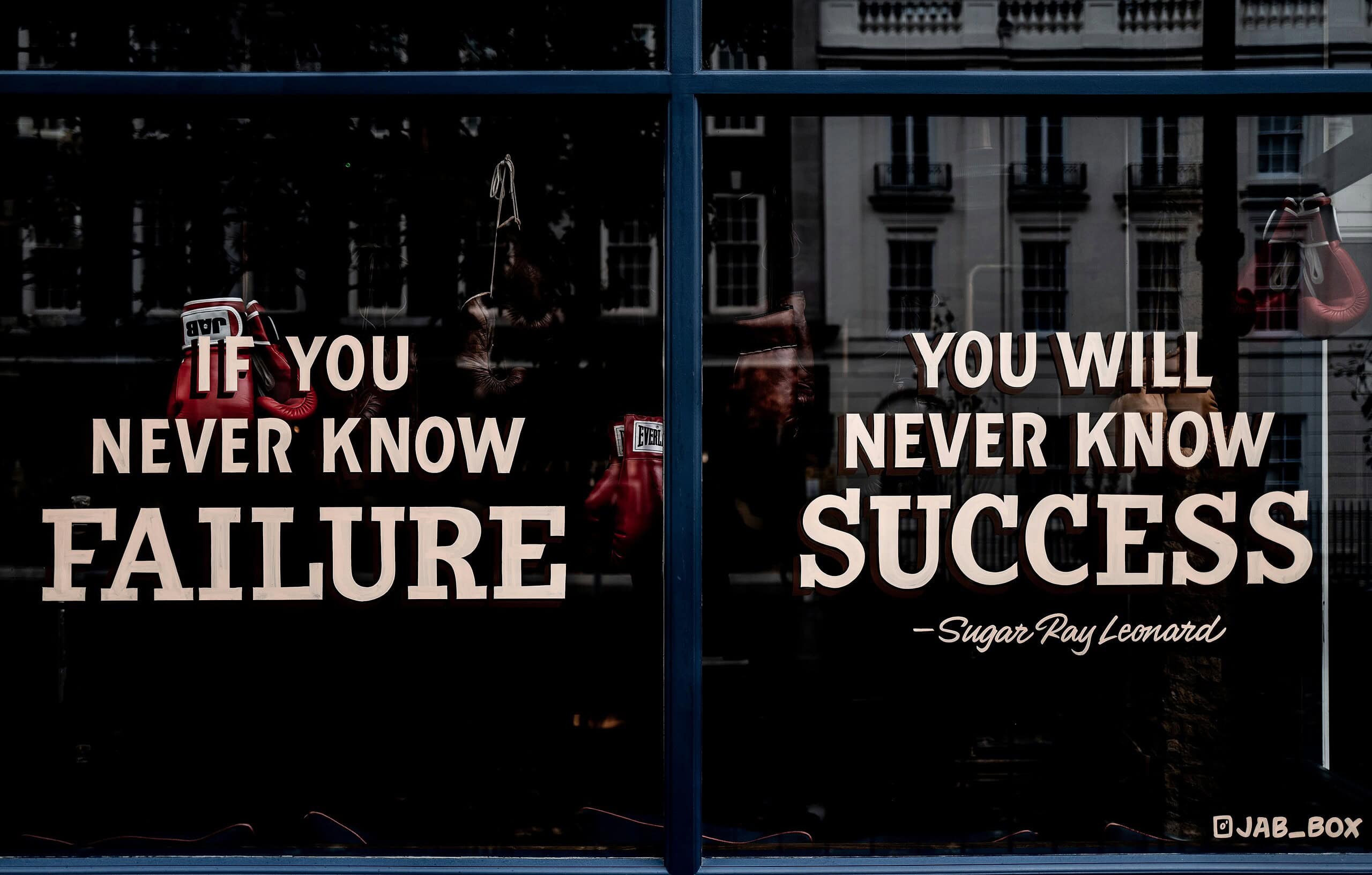Success motivation quote about failure and achievement displayed on glass window.